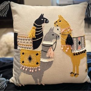 Decorative llama pillow with fringe.